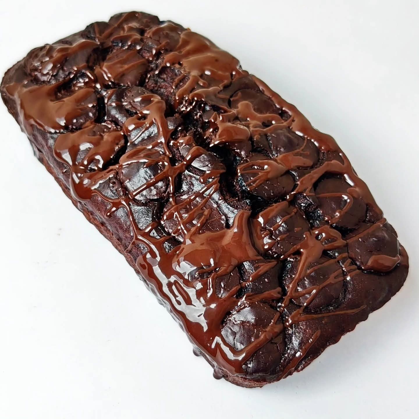 Singapore halal Chocolate banana bread loaf cake with a glossy chocolate glaze on a white background