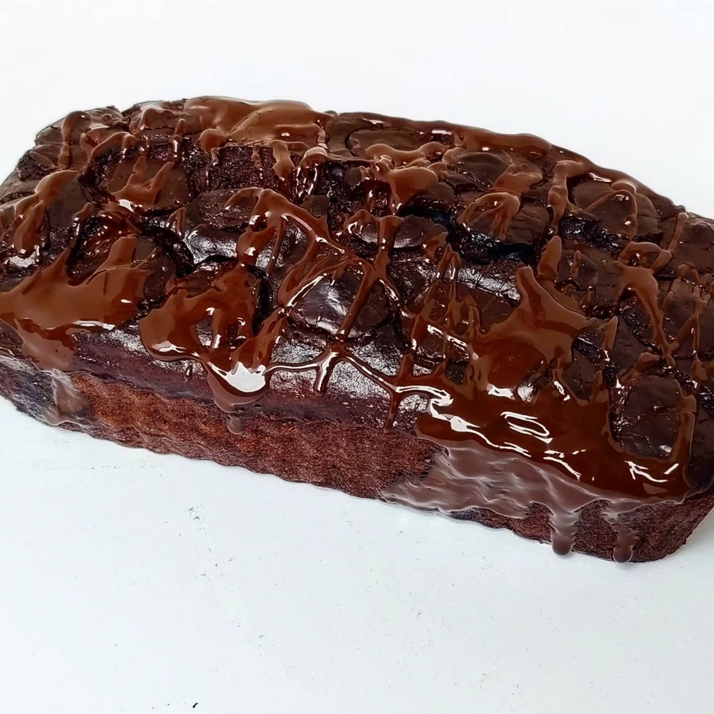 Singapore halal Chocolate loaf cake with a glossy chocolate glaze on a white background