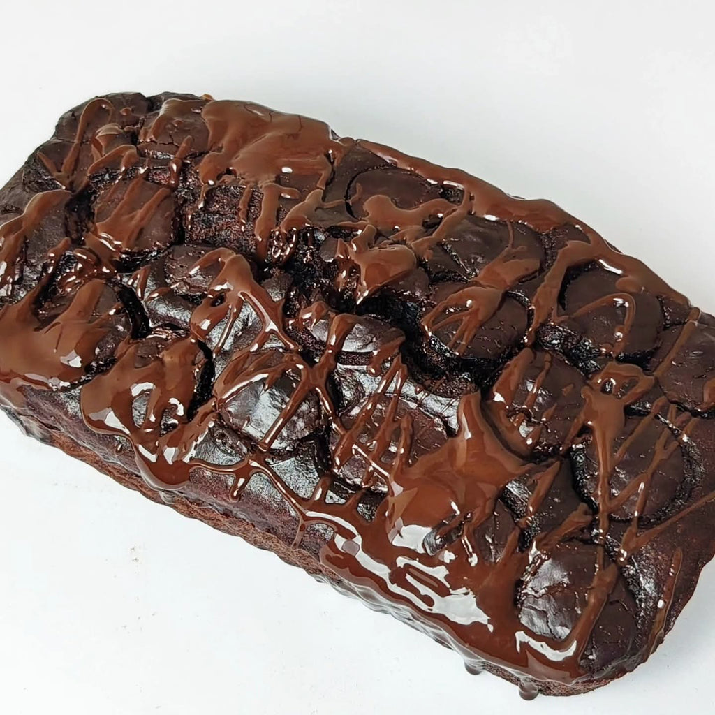 Singapore halal moist banana Chocolate cake with a glossy chocolate glaze on a white background